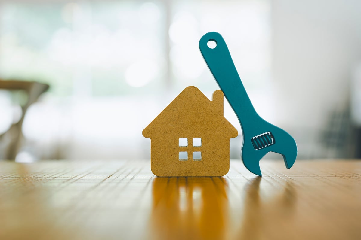 Maqueta de vivienda y llave inglesa, concepto de servicios del hogar