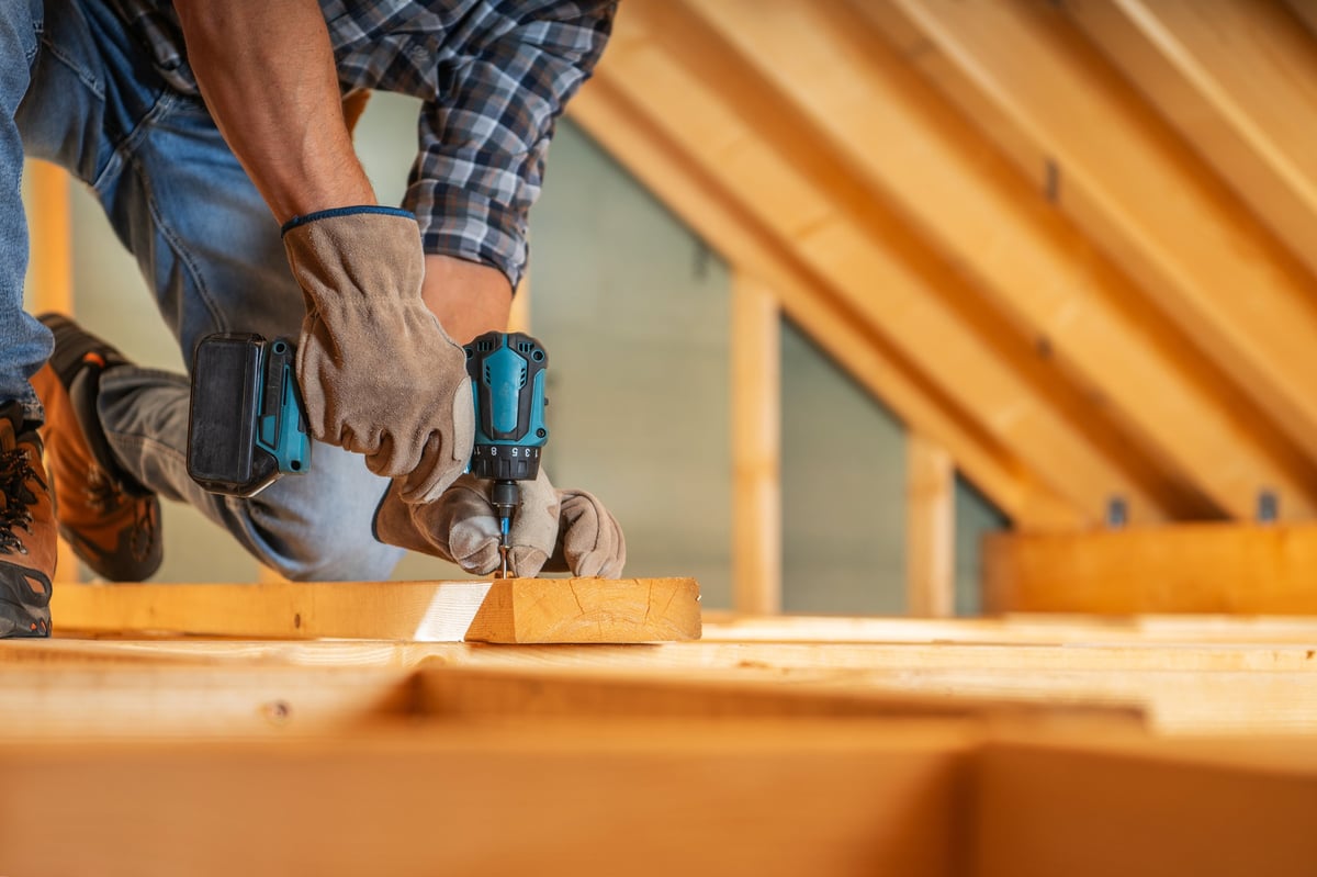 Profesional instalando una estructura de madera con taladro