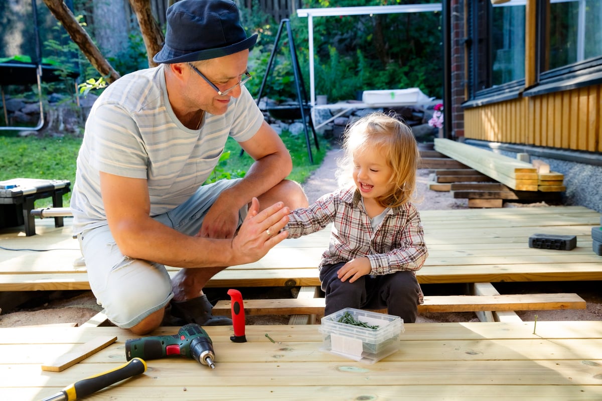 Padre e hija construyendo juntos una terraza de madera